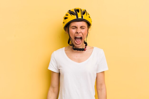 Junge hübsche Frau, die aggressiv schreit und sehr wütendes Fahrradkonzept sieht