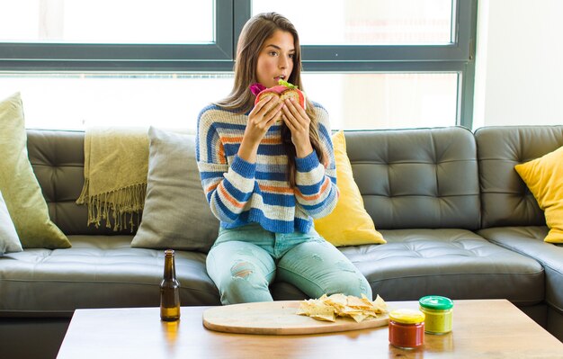 Foto junge hübsche frau, die auf couch innen entspannt