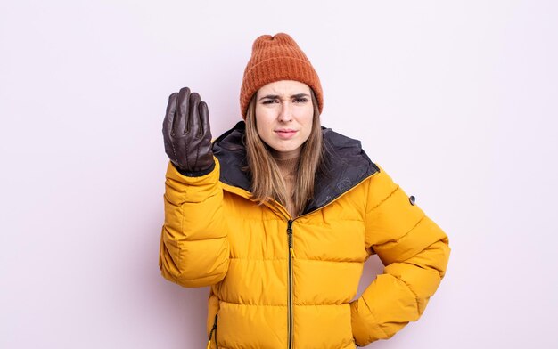 Junge hübsche Frau, die Capice oder Geldgeste macht und Ihnen sagt, dass Sie bezahlen sollen. Winterkonzept