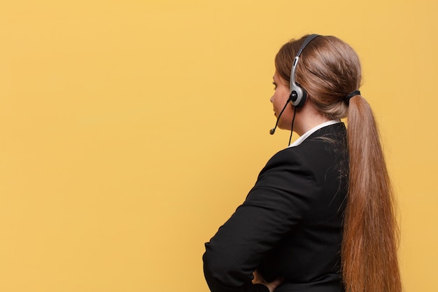 Junge hübsche Frau, die das Konzept des Telemarketers denkt oder anzweifelt