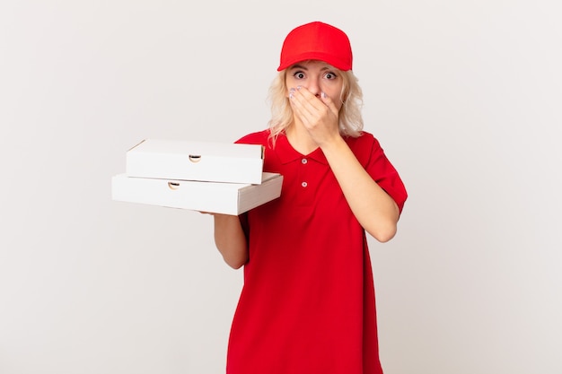 Junge hübsche Frau, die den Mund mit den Händen mit einem schockierten bedeckt. Pizza Lieferkonzept