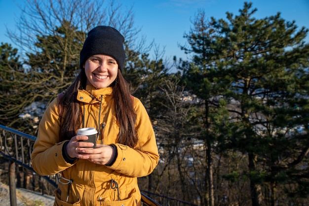 Junge hübsche Frau, die draußen Kaffee trinkt, kopieren Raum