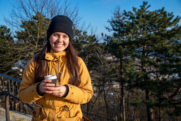 Junge hübsche Frau, die draußen Kaffee trinkt, kopieren Raum