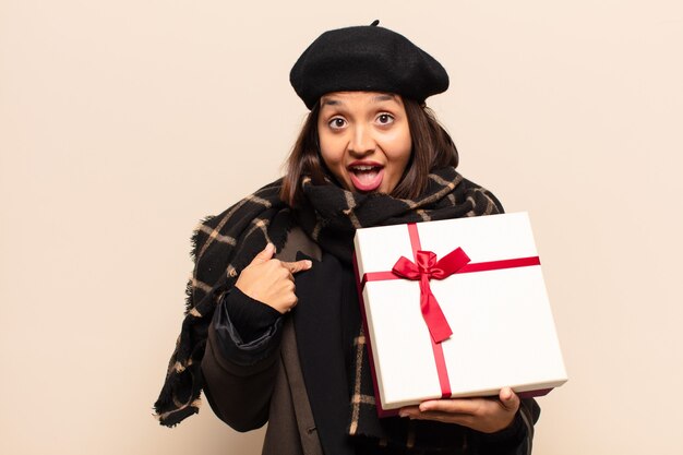 Junge hübsche Frau, die ein Geschenk hält