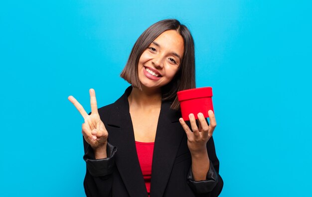 Junge hübsche Frau, die eine Geschenkbox hält