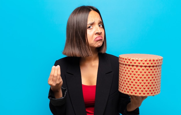 Junge hübsche Frau, die eine Geschenkbox hält