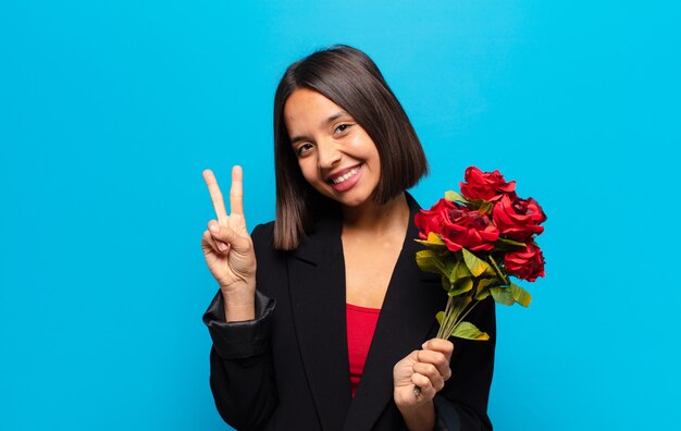 Junge hübsche Frau, die einen Strauß Rosen hält