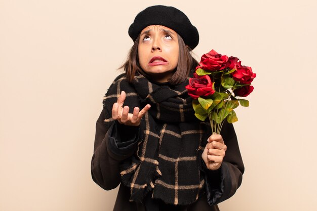 Junge hübsche Frau, die einen Strauß Rosen hält