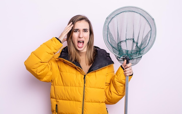 Foto junge hübsche frau, die glücklich erstauntes und überraschtes fischerkonzept aussieht