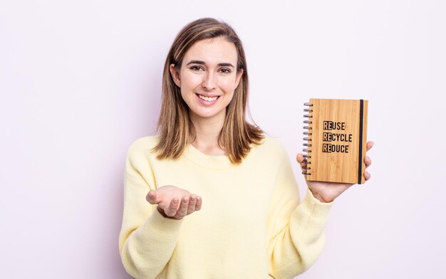 Junge hübsche Frau, die glücklich mit freundlichem Lächeln lächelt und ein Konzept anbietet und zeigt. Recycling-Konzept