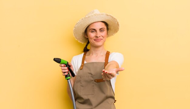 Junge hübsche Frau, die glücklich mit freundlichem Lächeln lächelt und ein Konzeptgarderingkonzept anbietet und zeigt