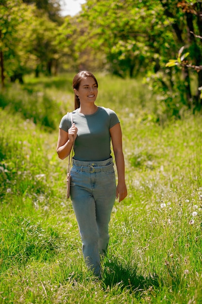 Junge hübsche Frau, die in den Wald geht