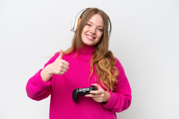 Junge hübsche Frau, die mit einem Videospiel-Controller spielt, isoliert auf weißem Hintergrund, mit einer Daumen-nach-oben-Geste