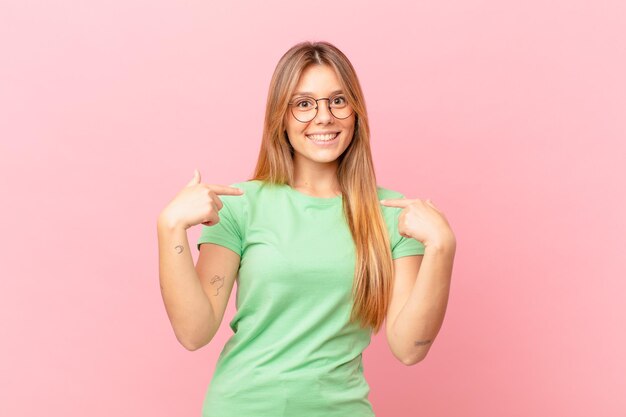 Junge hübsche Frau, die sich glücklich fühlt und aufgeregt auf sich selbst zeigt