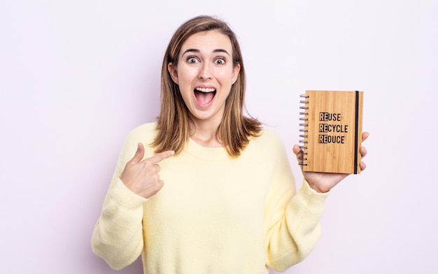 Junge hübsche Frau, die sich glücklich fühlt und mit einem aufgeregten auf sich selbst zeigt. Recycling-Konzept