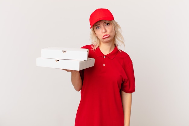 Junge hübsche Frau, die sich traurig und weinerlich mit einem unglücklichen Blick und Weinen fühlt. Pizza Lieferkonzept