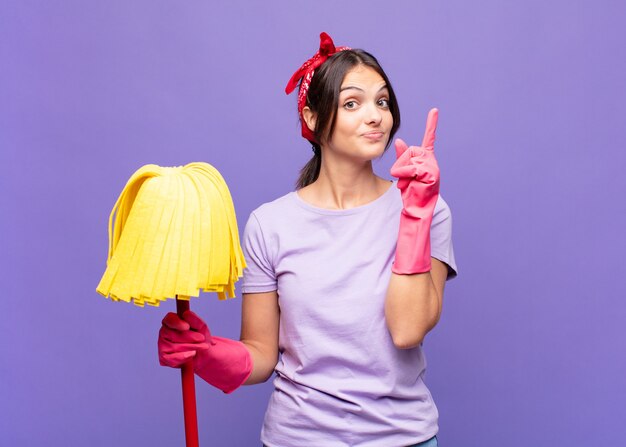 Junge hübsche Frau, die sich wie ein Genie fühlt, das stolz Finger in der Luft hält, nachdem sie eine großartige Idee verwirklicht und Eureka sagt