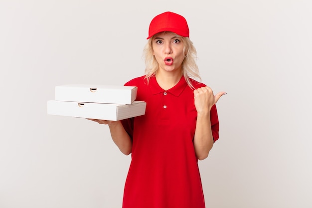 Junge hübsche Frau, die ungläubig überrascht schaut. Pizza Lieferkonzept