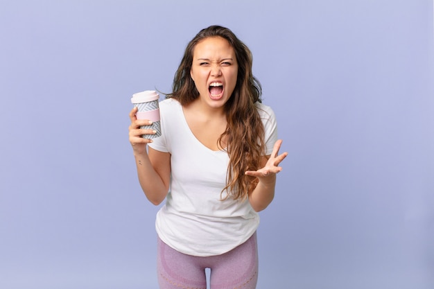 junge hübsche frau, die wütend, verärgert und frustriert aussieht und einen kaffee hält