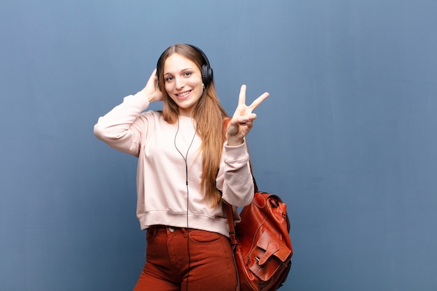 Junge hübsche Frau gegen blaue Wand mit einem Kopienraum