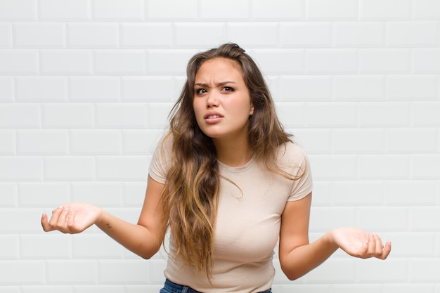 Foto junge hübsche frau gegen weiße wand