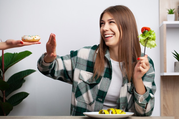 Junge hübsche Frau hält an Diät fest und wählt gesundes Essen