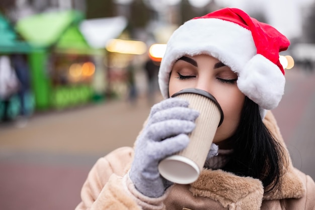 Junge hübsche Frau hält heißes Getränk trinken Kaffee