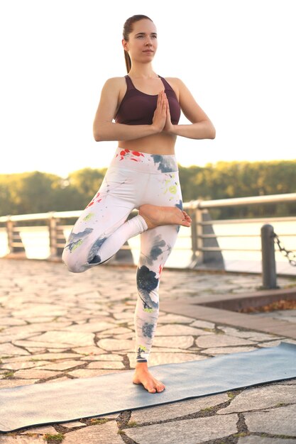 Junge hübsche Frau macht Yoga-Übungen im Park.