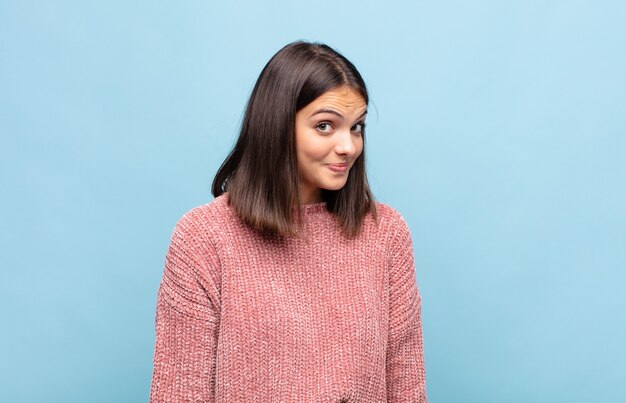 Junge hübsche Frau mit einem albernen, verrückten, überraschten Ausdruck, pochenden Wangen, fühlte sich gestopft, fett und voller Essen