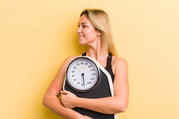 Junge hübsche Frau mit einem Gewichtsbalance-Fitness- und Diätkonzept