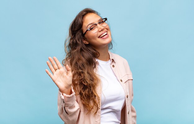 junge hübsche Frau mit einem großen, freundlichen, sorglosen Lächeln, das positiv, entspannt und glücklich aussieht, chillt. Hauptkonzept