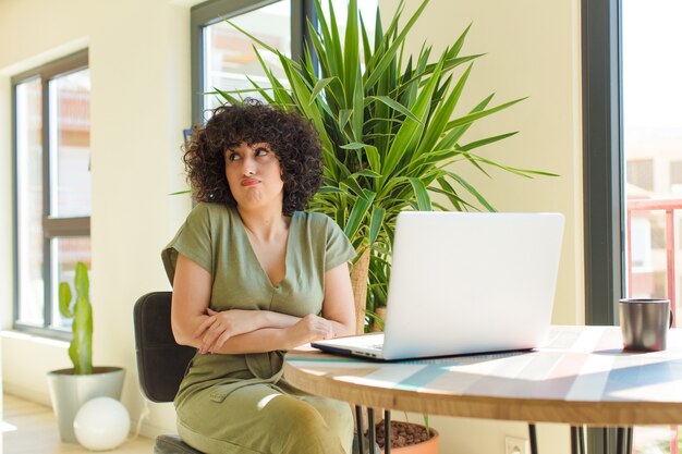 Junge hübsche Frau mit einem Laptop auf einem Tisch