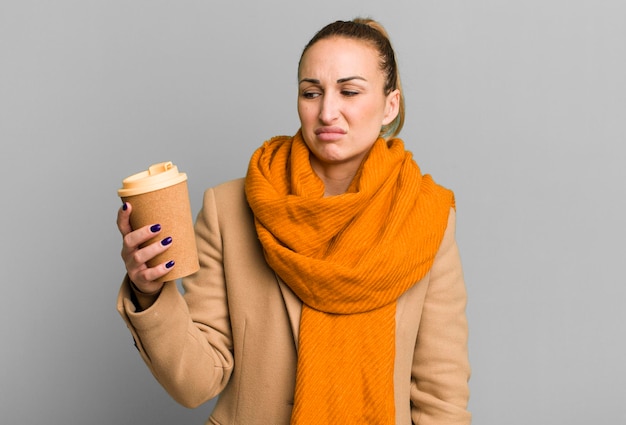 Junge hübsche Frau mit einem Mitnehmerkaffee