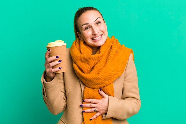 Junge hübsche Frau mit einem Mitnehmerkaffee