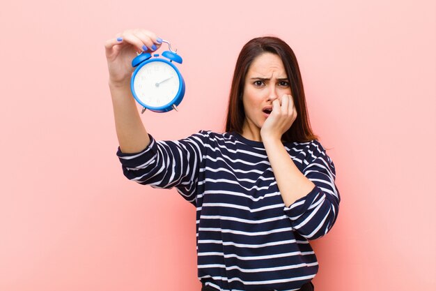 Junge hübsche Frau mit einer Uhr. Zeitkonzept