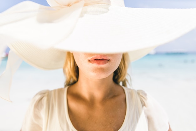 Foto junge hübsche frau mit hut am strand