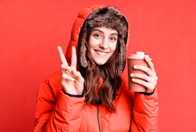 Junge hübsche Frau mit Winterkleidung und einem heißen Kaffee kalt und Winterkonzept