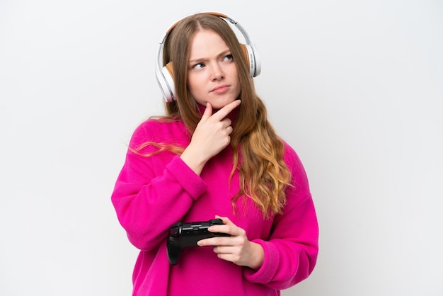 Junge hübsche Frau spielt mit einem Videospiel-Controller isoliert auf weißem Hintergrund und hat Zweifel