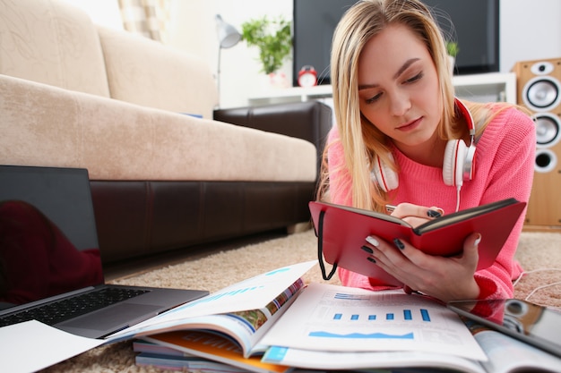 Junge hübsche Frau Studie am Wohnzimmer halten Buch in den Armen