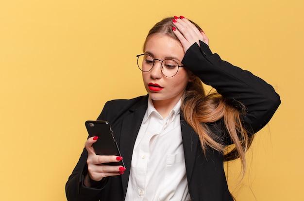 Junge hübsche Frau verwirrter Ausdruck Smartphone-Konzept