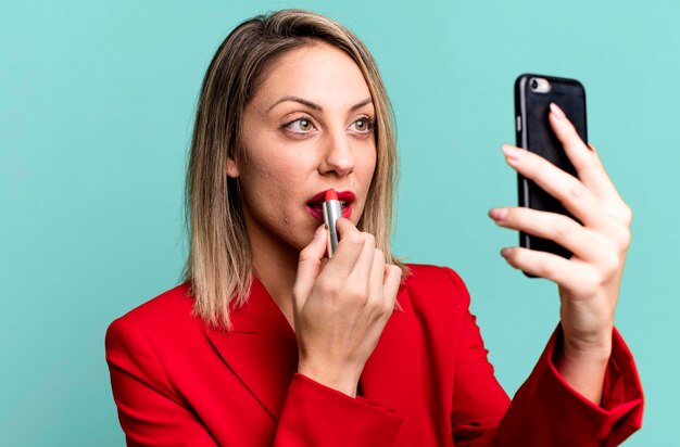 Junge hübsche Geschäftsfrau, die ihr intelligentes Telefon verwendet