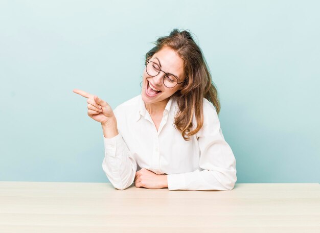 Junge hübsche Geschäftsfrau, die mit einer Tabelle sitzt