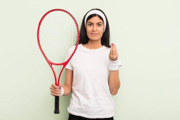 Junge hübsche hispanische frau, die capice oder geldgeste macht, die ihnen sagt, sie sollen das tenniskonzept bezahlen