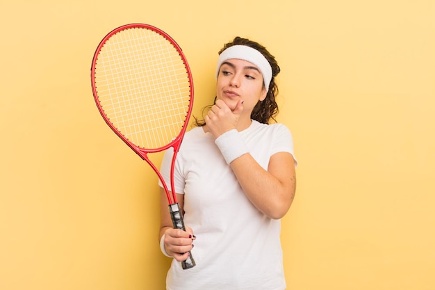 Junge hübsche hispanische frau, die denkt, dass sie sich zweifelhaft und verwirrt im tenniskonzept fühlt