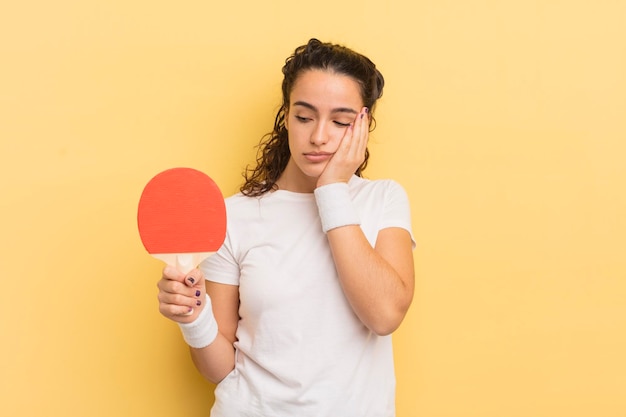 Junge hübsche hispanische Frau, die sich nach einem ermüdenden Ping-Pong-Konzept gelangweilt, frustriert und schläfrig fühlt