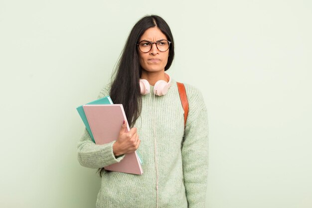 Junge hübsche hispanische Frau, die sich traurig, verärgert oder wütend fühlt und zur Seite schaut. studentisches Konzept