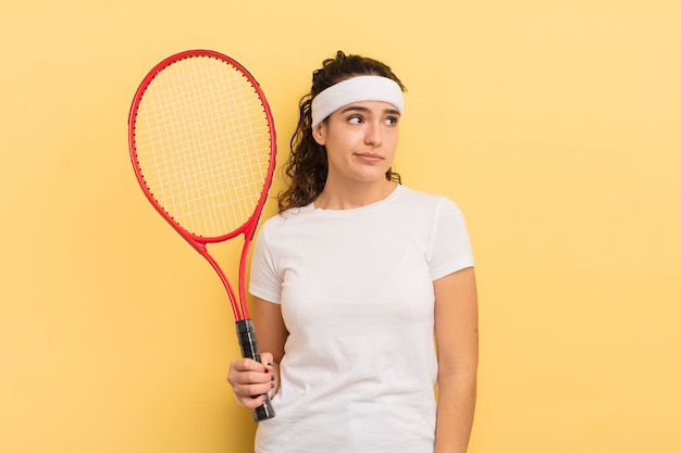 Junge hübsche hispanische Frau, die sich traurig, verärgert oder wütend fühlt und zur Seite schaut. Tennis-Konzept