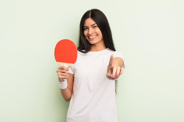 Junge hübsche hispanische Frau, die stolz und selbstbewusst lächelt und das Ping-Pong-Konzept Nummer eins macht