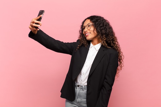 Junge hübsche hispanische Frau macht Selfie