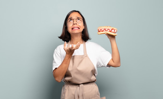 Junge hübsche Kochfrau mit Hot Dog